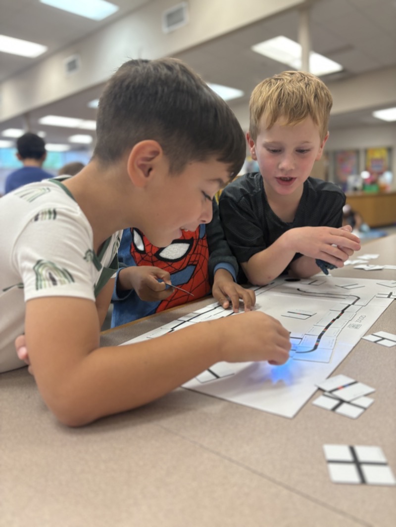 Young learners programming Ozobot robots with coding cards in the Vienna.i.Lab